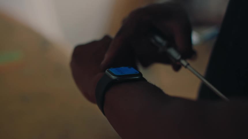 A persons wrist wearing a watch and clicking on its screen