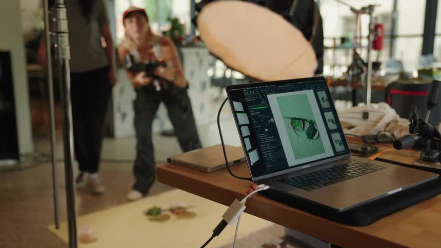 A photographer captures images of products in a restaurant with a laptop connected to the camera
