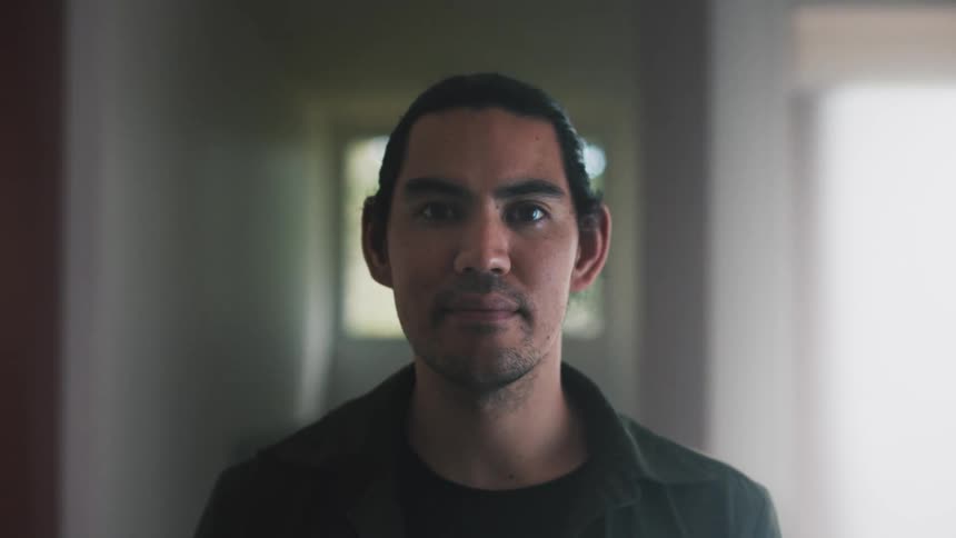 Portrait of a bearded man with a happy facial expression in a hallway
