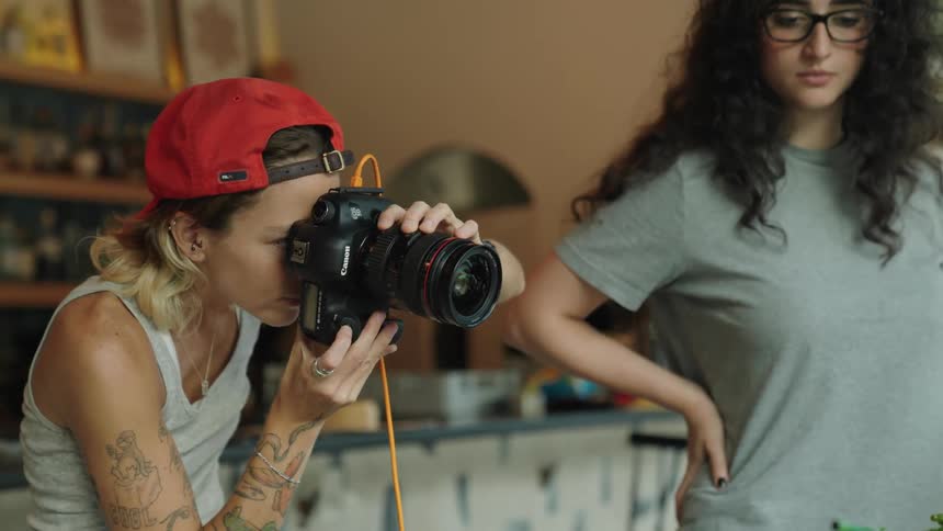A photographer and her assistant are taking pictures of products in a restaurant