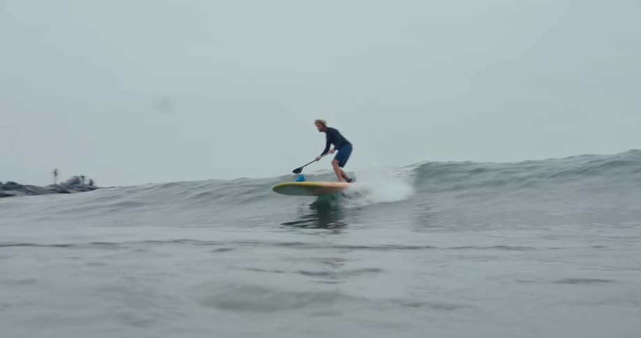 Man with a long surfboard riding a wave