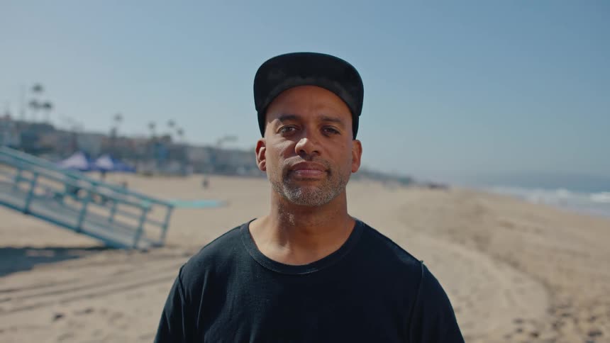 Portrait of a bearded man with a cap on the beach