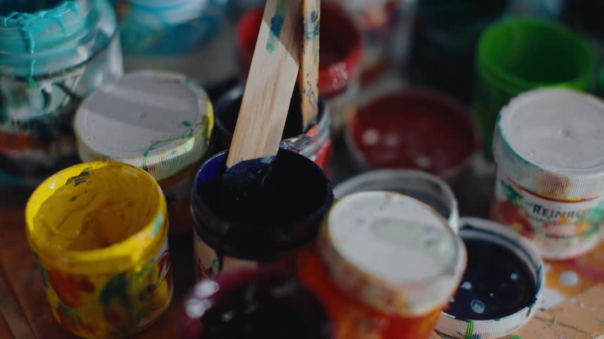 Close up of a table with several tubes of paint