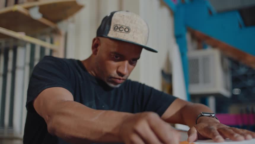 Man carefully finishing the details of a surfboard