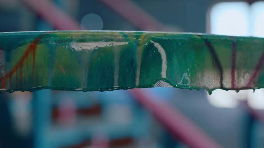 An object painted green with a few drops of paint dripping on it