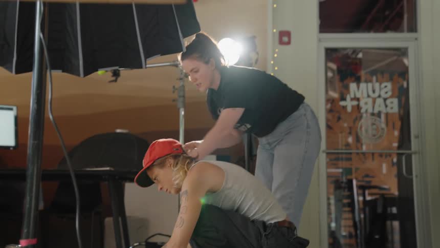Two women preparing a food scene with lights and equipment around