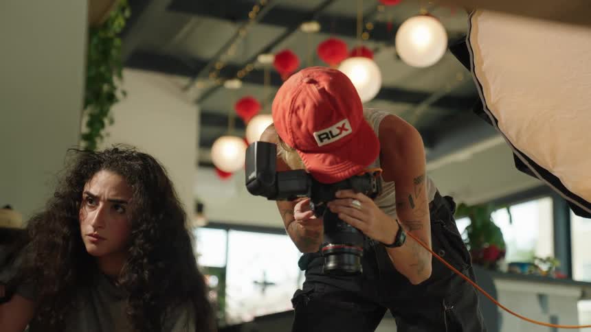 A photographer uses a digital camera to take pictures inside a restaurant