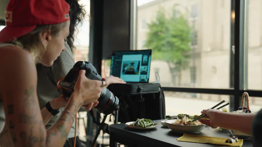 Photography team takes and reviews pictures of food at a restaurant