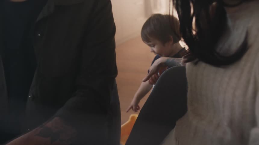A toddler shows his parents a toy by pointing to it