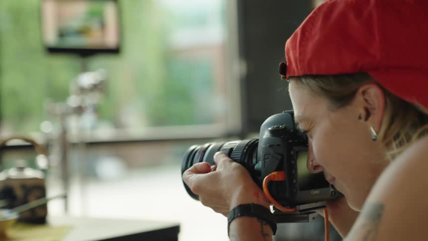 Woman taking pictures and the photos appear in real time on a screen in the background