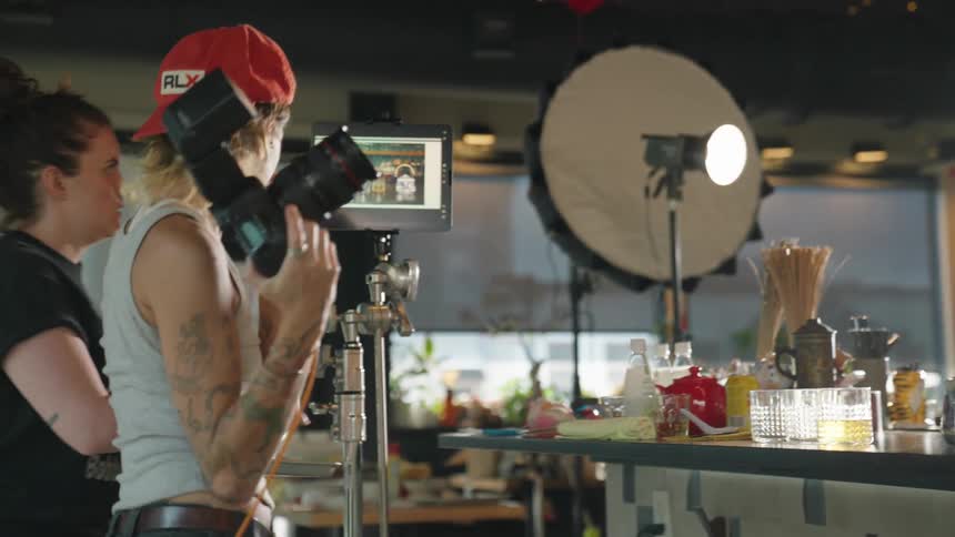 Two female photographers setting the scene with glasses and drinks with ice