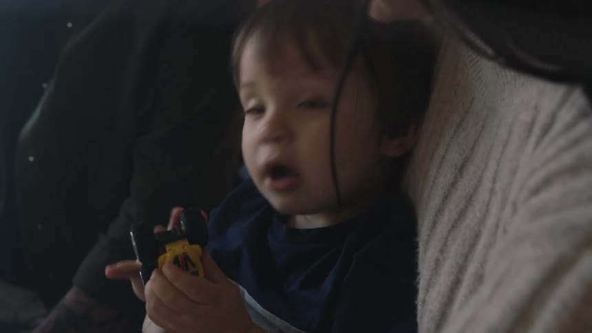 Portrait of a small boy sitting on his mothers lap next to his father