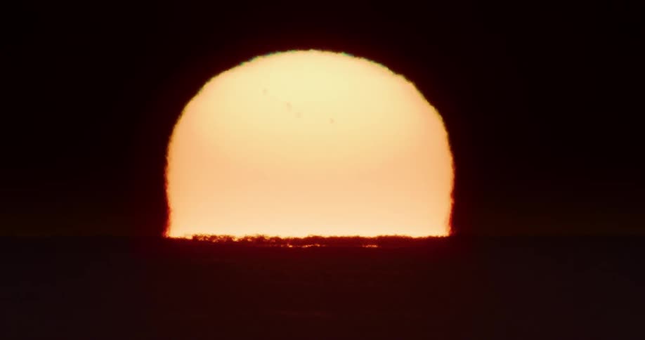The sun rises over a body of water