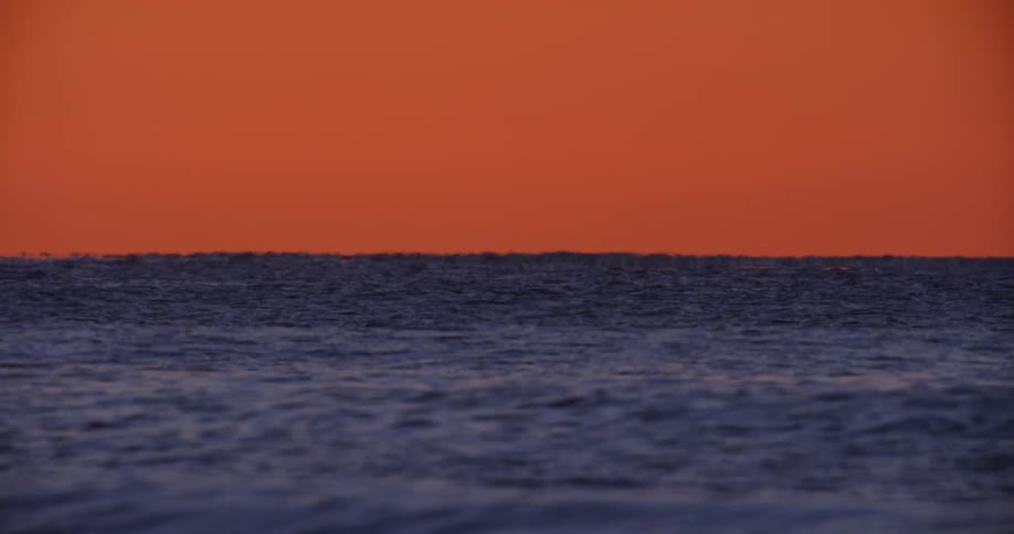 Vast calm sea with orange horizon
