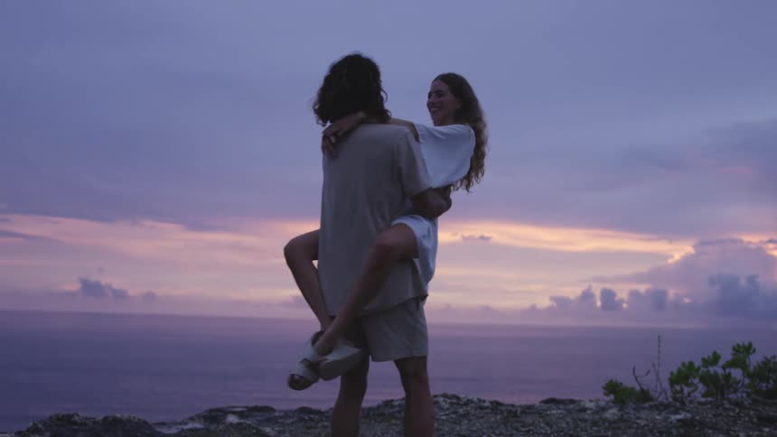 A man carries a woman and spins in a circle