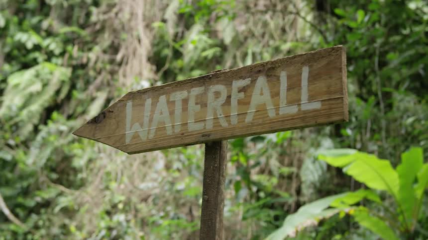 A sign that says waterfall points to the left