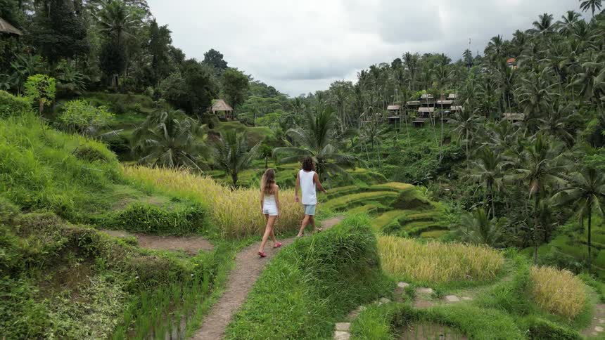 Man and woman walking on a hill surrounded by tropical vegetation
