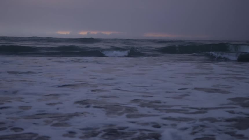 A twilight seascape with waves approaching the shore
