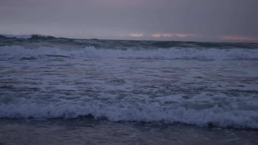 A twilight seascape with waves approaching the shore