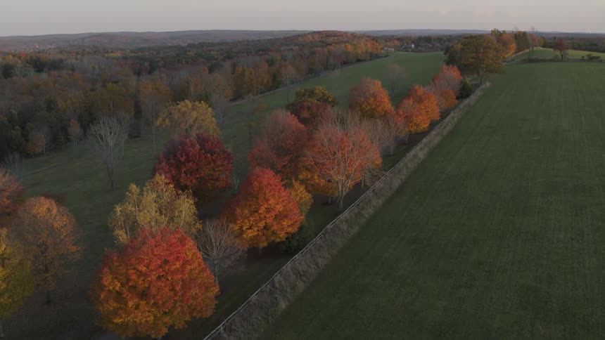 Fall is in the air as the trees take on vibrant hues of red, orange, and yellow along the countryside