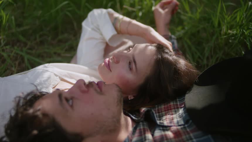 Close up of two people lying on grass next to each other