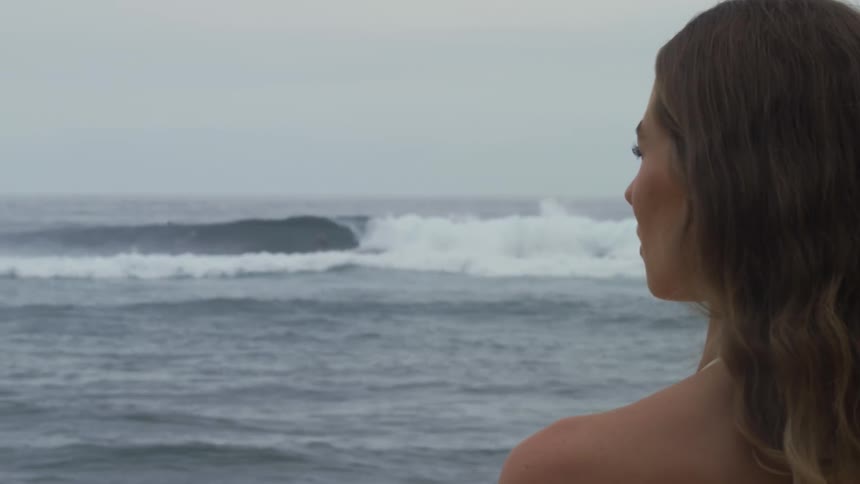 Side portrait of a woman watching the waves on a beach