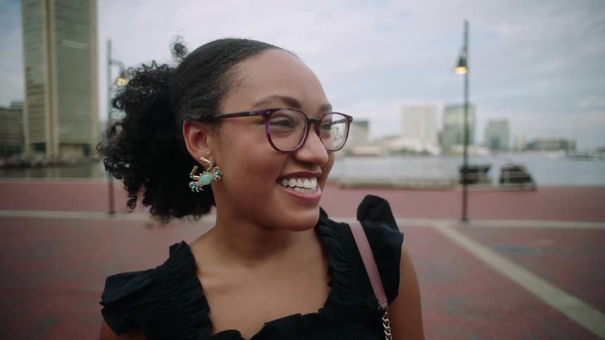A closeup of the face of a young woman turning her head around and then looking at the camera