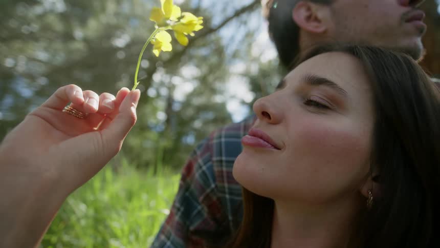 A man and woman sit together in the grass