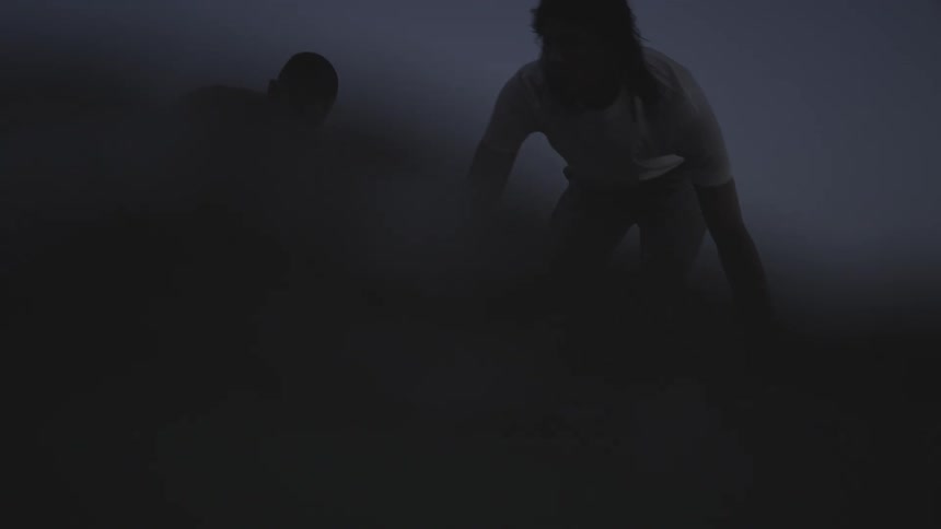 Two people in a shallow sea on a cloudy day