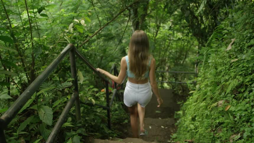 Woman walking down the stairs in a natural environment surrounded by vegetation