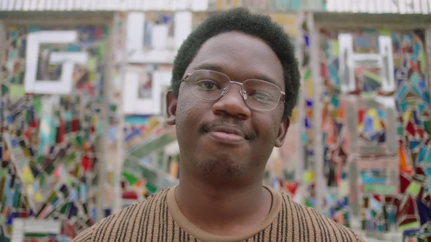 Portrait of a man wearing prescription glasses against a colored background
