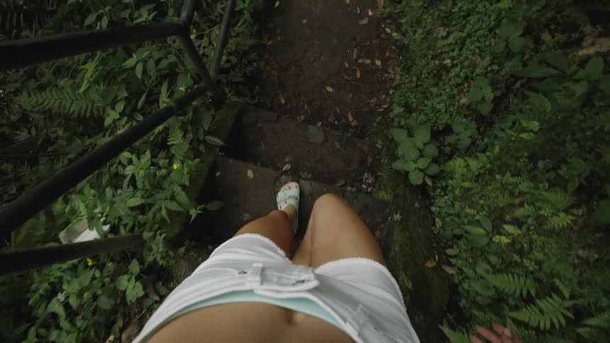Point of view of a womans legs walking down the stairs on a forest trail