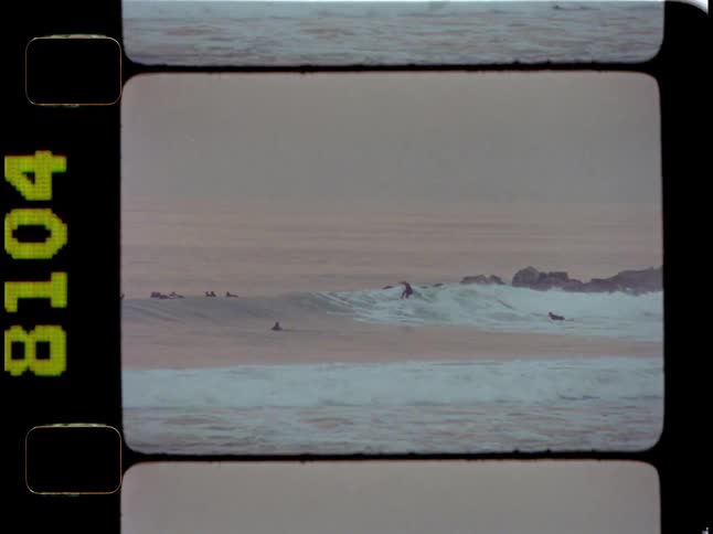 Group of surfers in the middle of the sea surfing waves
