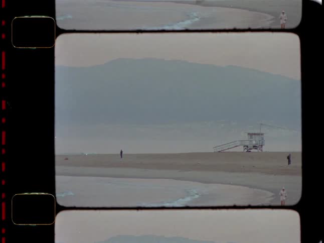A tranquil scene with a lifeguard tower overlooking a serene deserted beachscape caught on vintage film