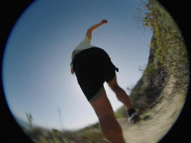 Man running along a trail in a mountainous environment