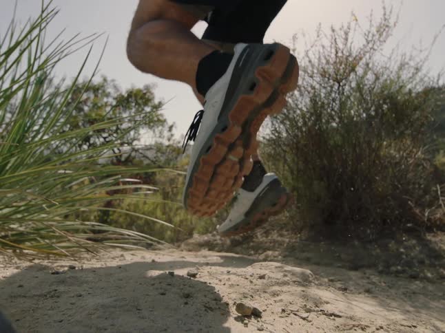 Legs of a man running with trail shoes in the natural environment