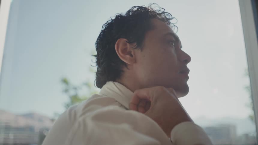 Man adjusting his shirt collar with his tie