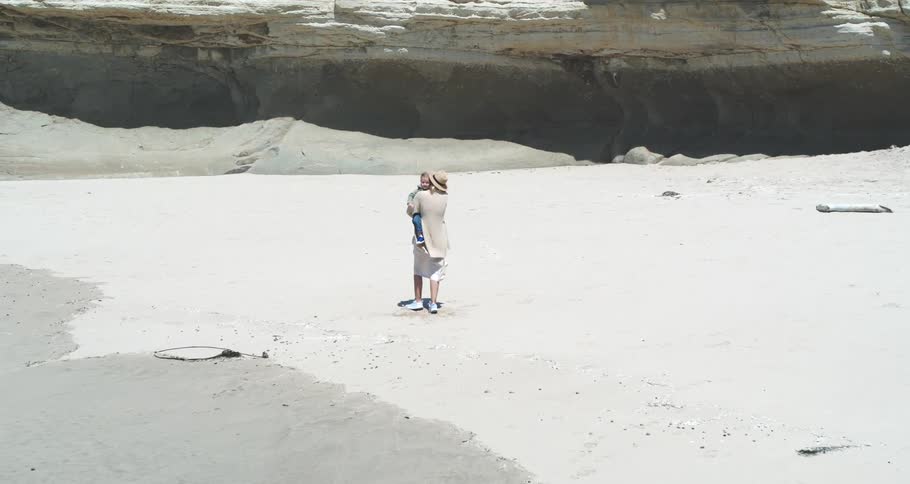 A woman is playing with her daughter on the beach