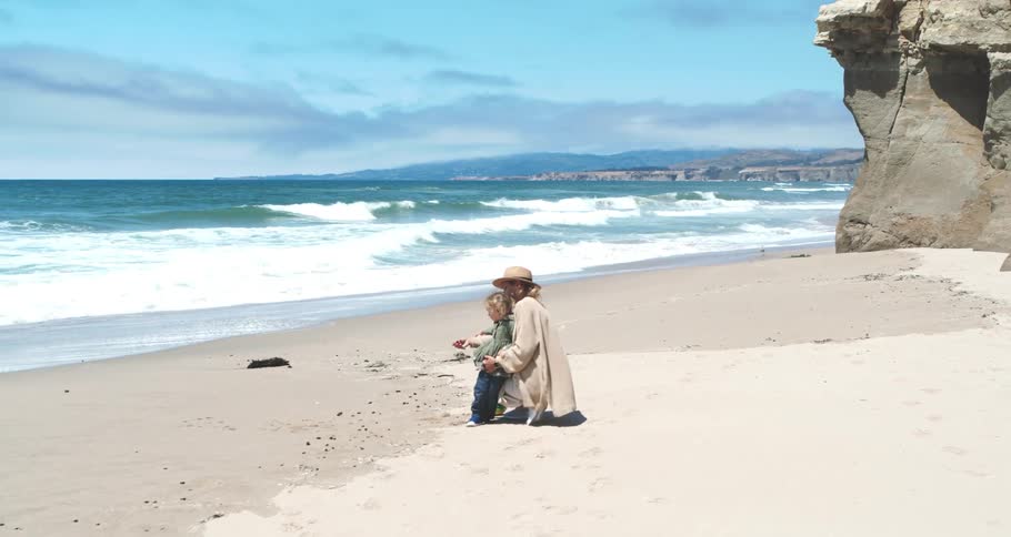 A woman and child hug on the beach