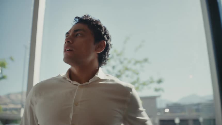 Man rubbing his face and walking in an office environment