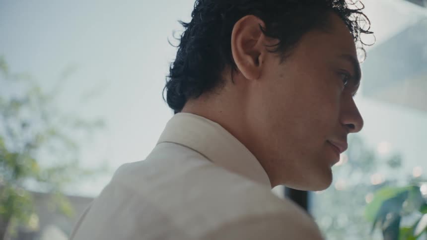 Side portrait of a man in a white dress shirt indoors