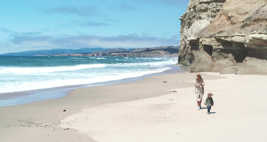 A mother and daughter walk on the beach