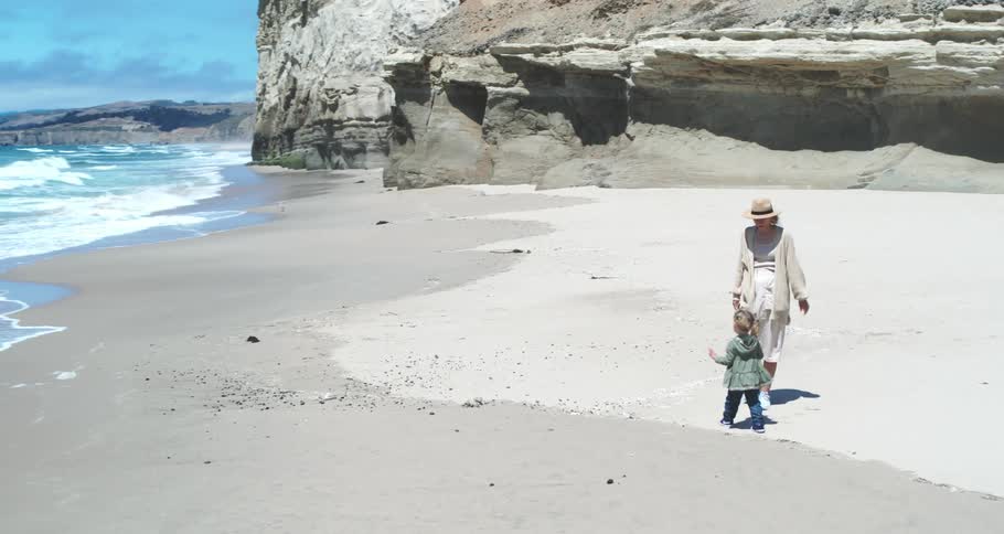Mother with her daughter on the beach sand