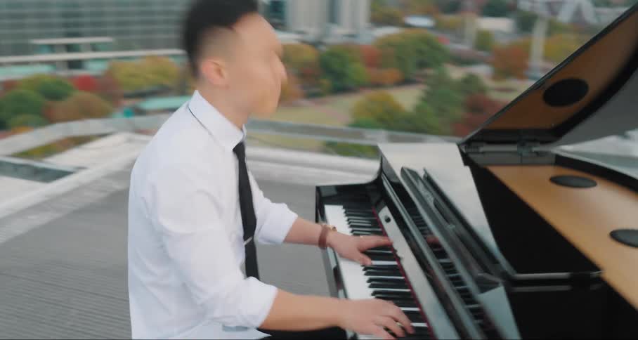 Male pianist plays piano on a rooftop in the city with great emotion