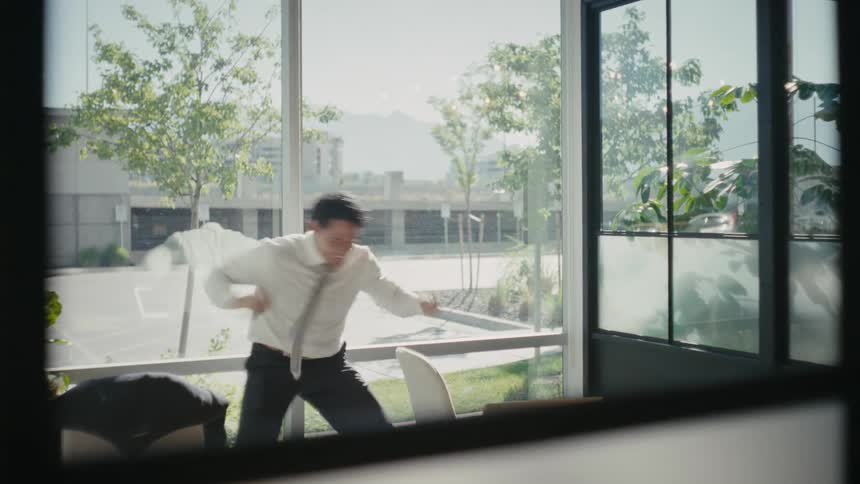 Man in an office room cheering happily