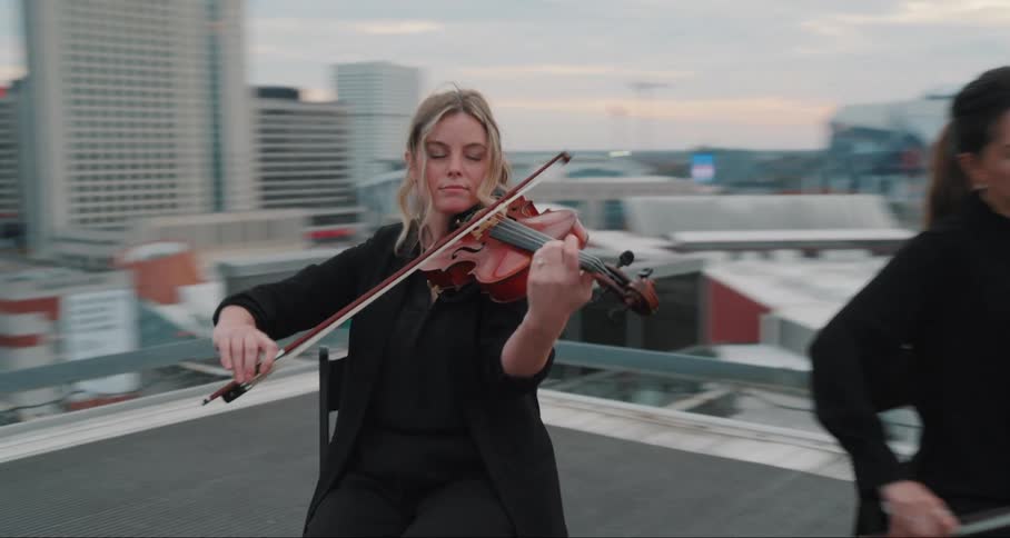 Group of people on a terrace of a building playing the violin