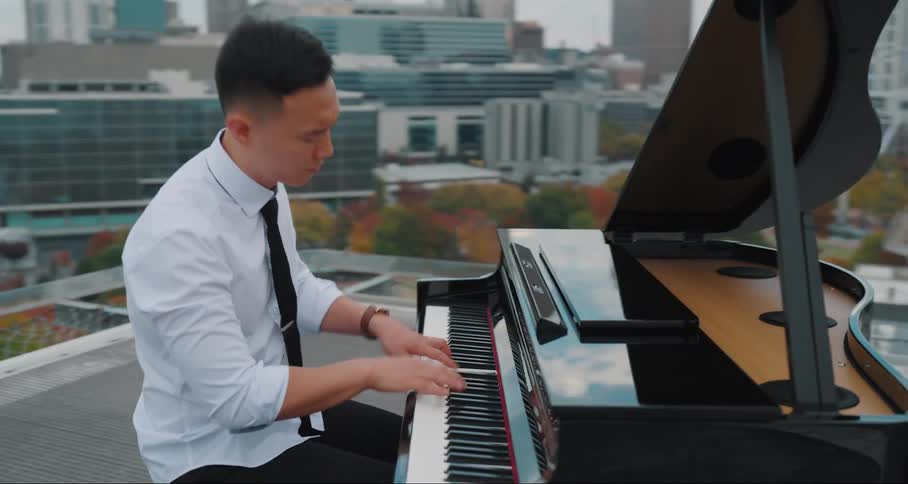 Young man playing the piano on the terrace of a building