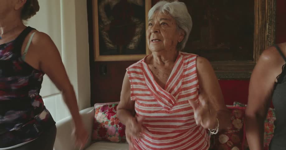 Three women are exercising with an exercise video