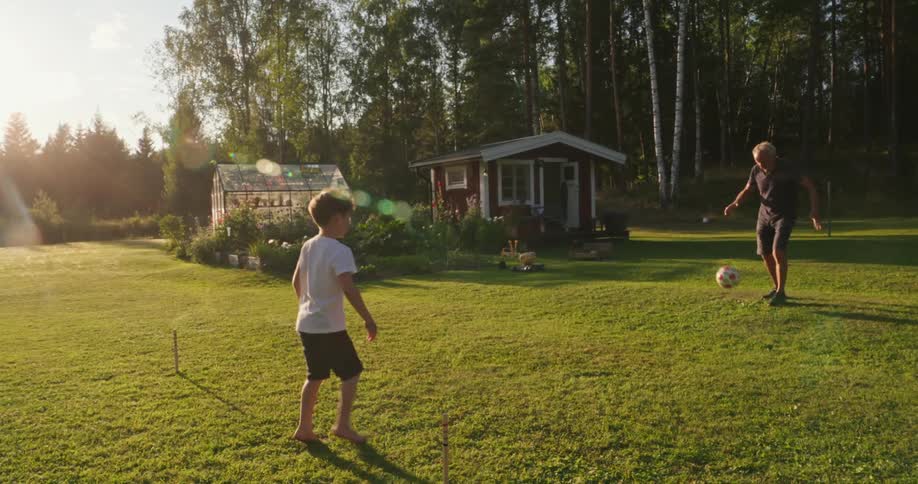 A grandfather and grandson play soccer together