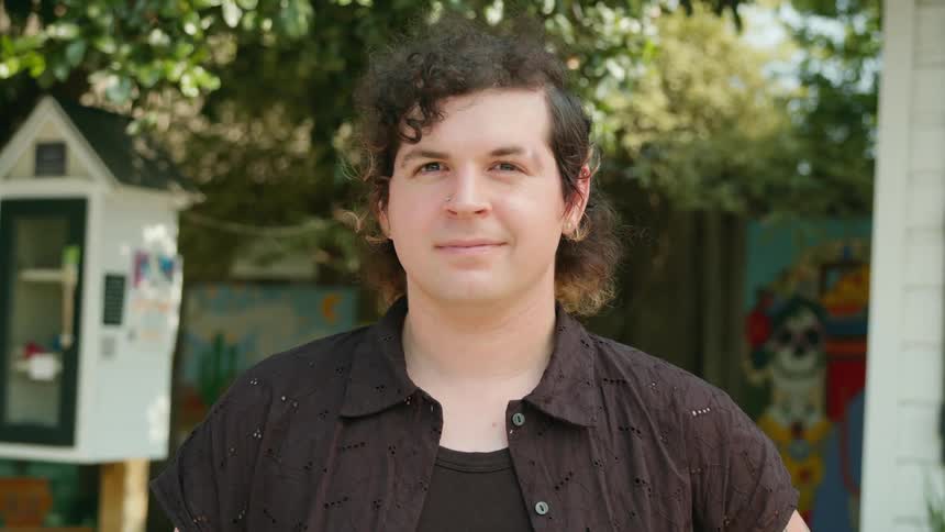 Portrait of a man with a happy facial expression in an outdoor environment with trees